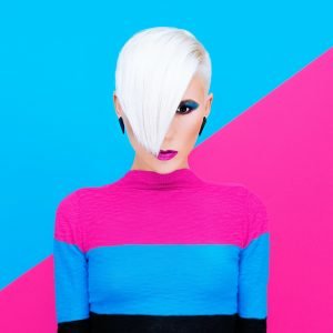 Fashion blond model with trendy hairstyle and make-up on a color