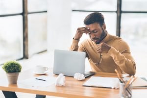 Frustrated black businessman taking off glasses massaging nose
