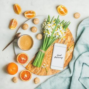 Coffee, cookies, oranges, flowers and mobile phone with Good morning