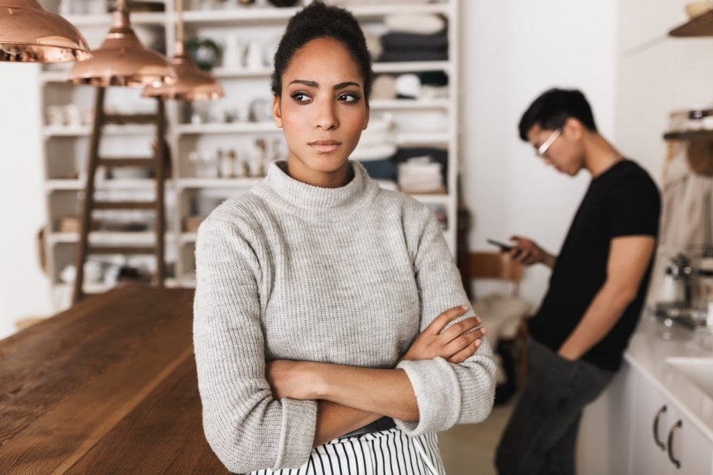 Young international couple in quarrel spending time on kitchen at home