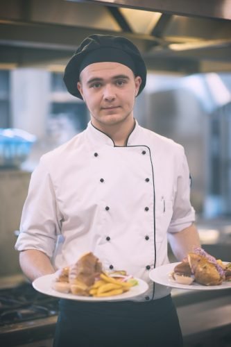Chef showing dishes of tasty meals Chef showing dishes of tasty meals