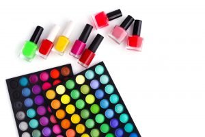 Set of decorative cosmetics and coloured nail polish bottles on