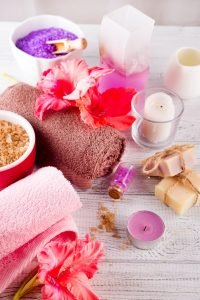 Spa set with flower, candle, bath soap and massage salt on wooden background