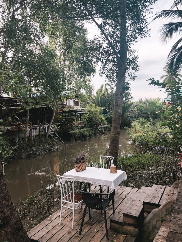 Cafe tables and chairs outside with local tropical background