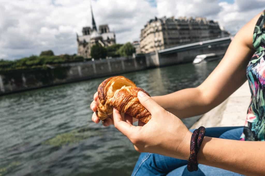 Girl eating croissant in Paris