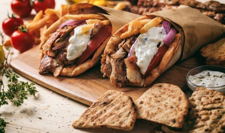 Greek gyros wrapped in pita breads on a wooden table