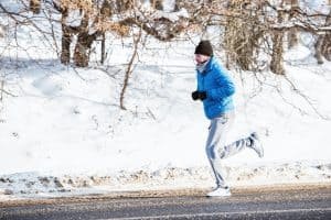 Fitness trainer working out on snow on a cold winter day in the
