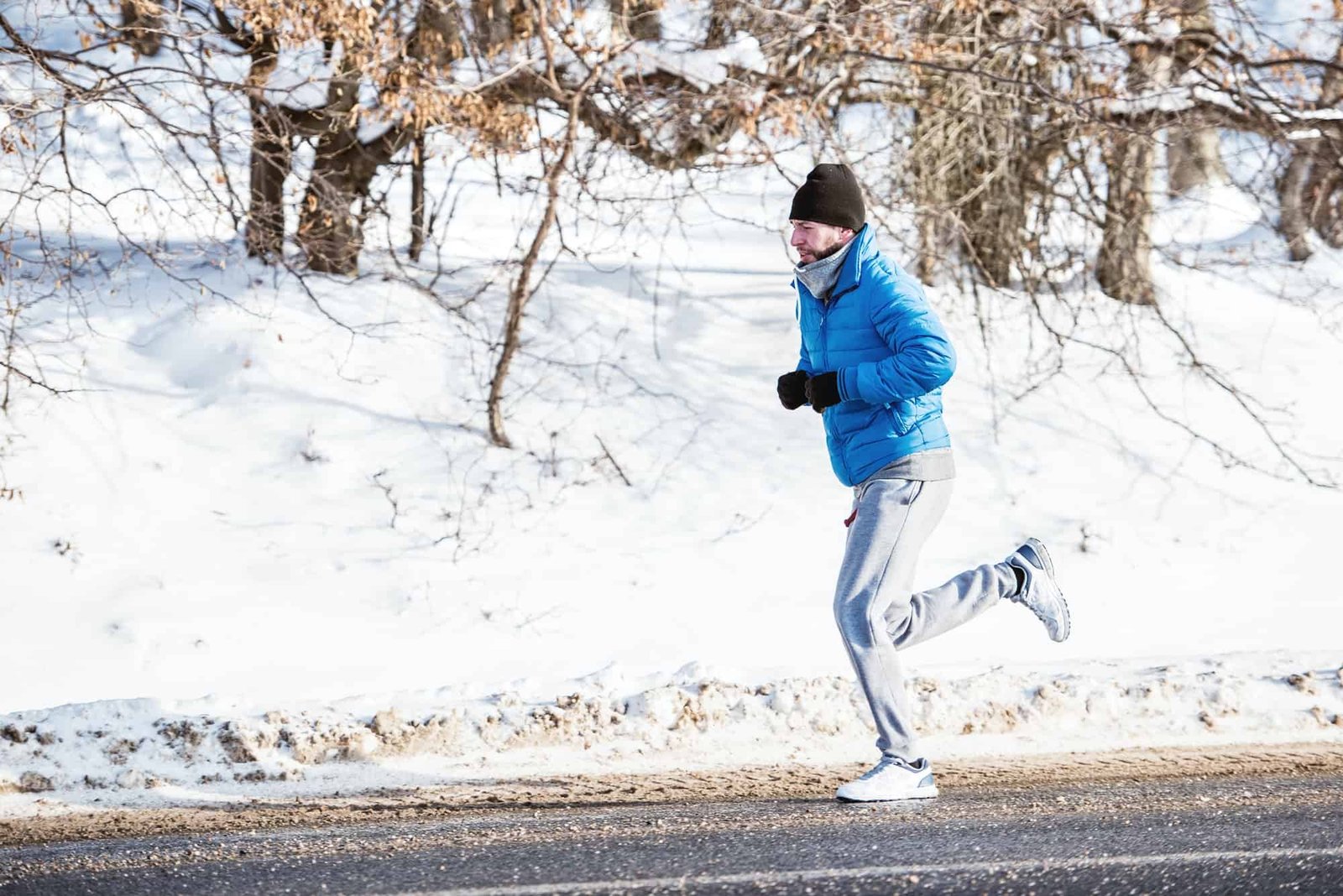 Fitness trainer working out on snow on a cold winter day in the
