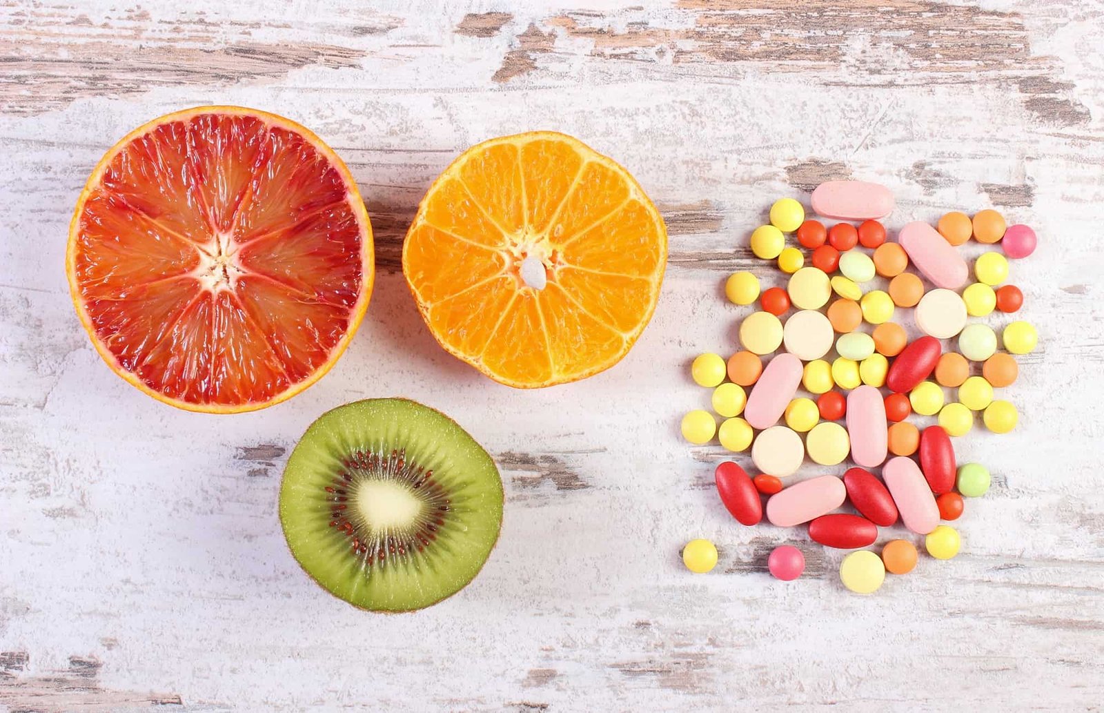 Fresh fruits and colorful medical pills, choice between healthy nutrition and medical supplements