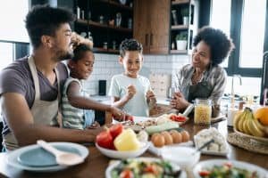 Happy family in the kitchen having fun and cooking together. Healthy food at home