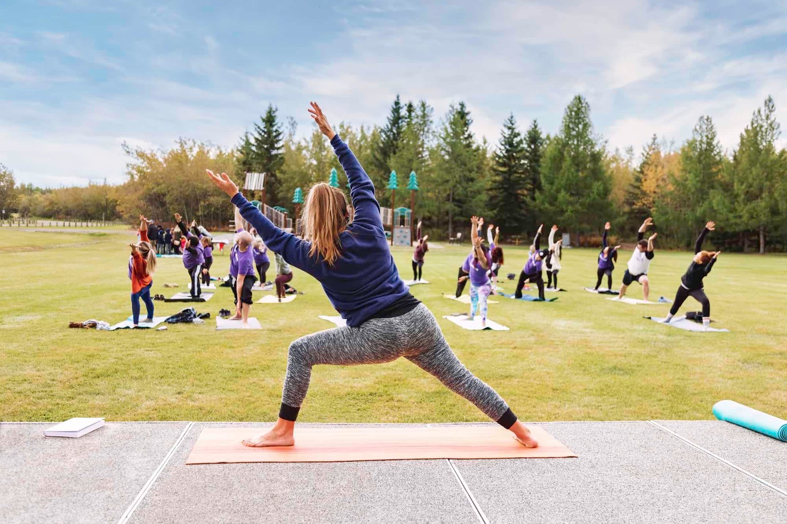 Outdoor Yoga classes. Group of adults attending yoga classes in the park.