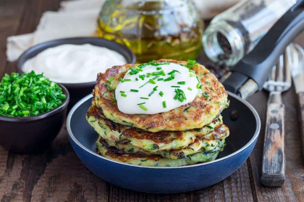 Vegetarian zucchini fritters or pancakes, served with greek yogu