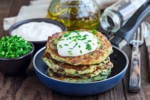 Vegetarian zucchini fritters or pancakes, served with greek yogu