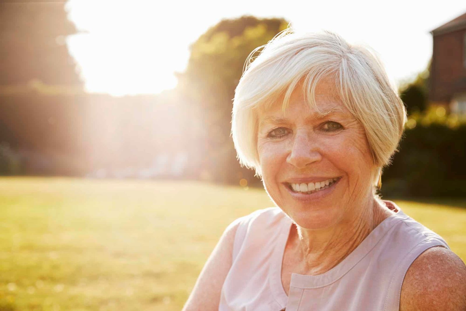 Senior woman in the garden, smiling to camera, close up