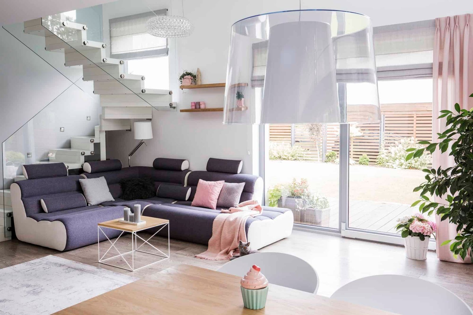Transparent light shade above a wooden dining table in a white l