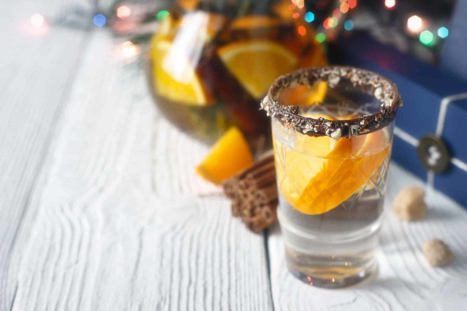 Citrus cocktail in the decorated glass on the white wooden table