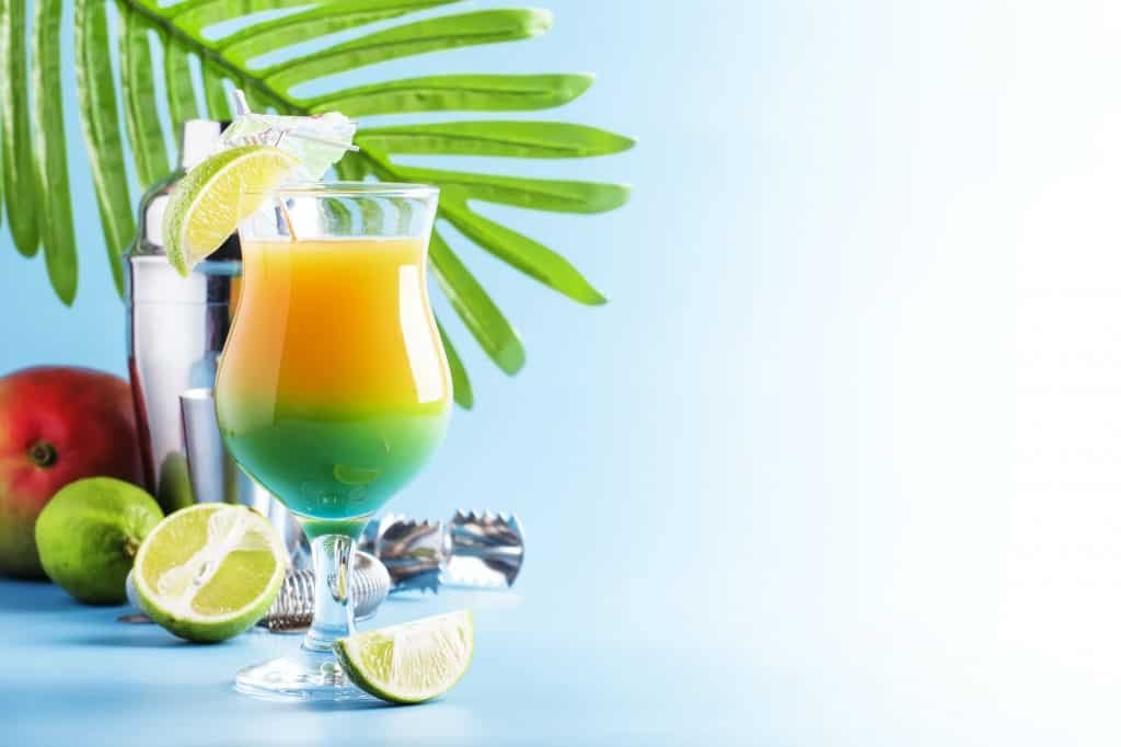 Double layer green yellow alcoholic cocktail with mango juice, rum, liqueur, lime and ice
