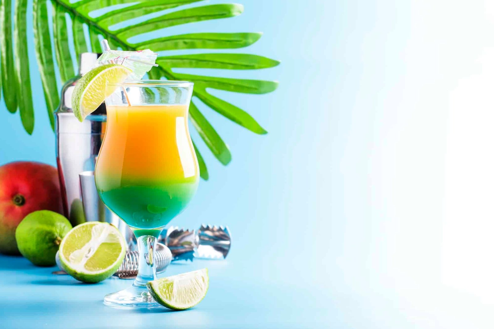 Double layer green yellow alcoholic cocktail with mango juice, rum, liqueur, lime and ice