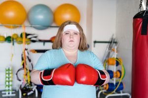 Overweight Woman Boxing in Gym