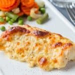 Baked cod fish fillet under cheese, mustard, pepper and cream cr