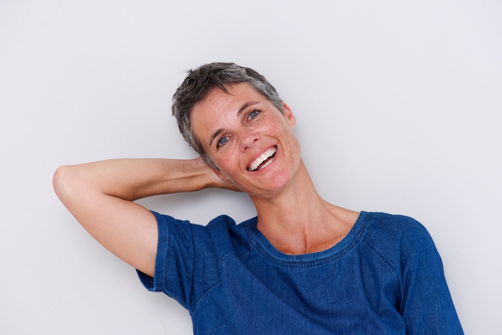 happy older woman with hand behind head