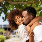 Outdoor protrait of black african american couple kissing each o