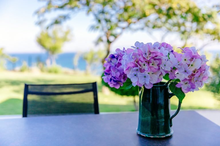 bouquet of pink and purple flowers in a vase on the table in the garden