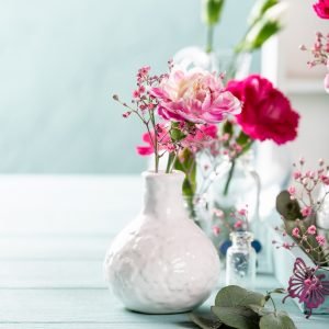 Bouquet of pink carnation on light turquoise wooden background