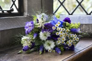 Close up of a bouquet of blue and white wedding flowers.