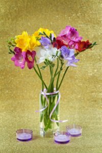 Colorful of freesia in vase and candles