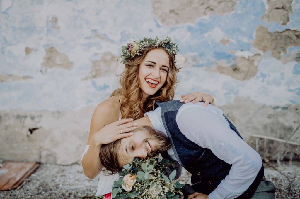Beautiful bride and groom in front of old shabby house.