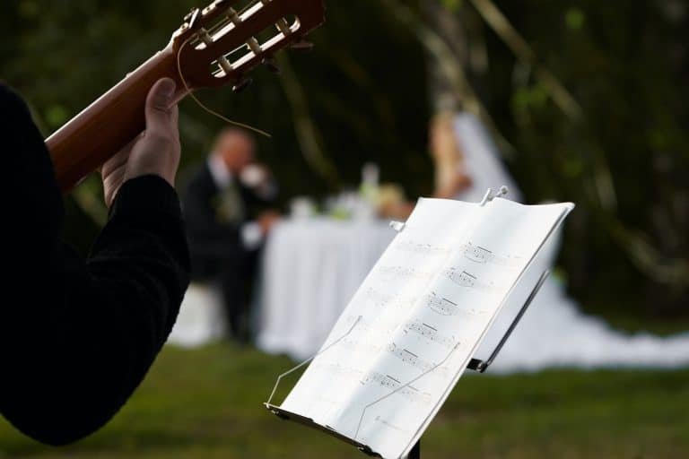 Cropped image of a musician and a rack with notes against a pair of newlyweds.