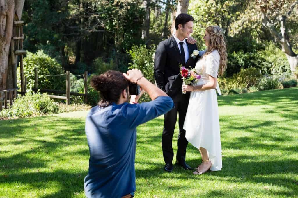Photographer taking photo of newly married couple