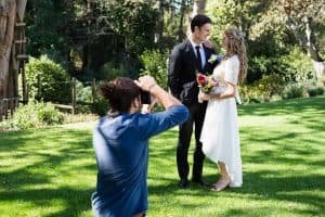 Photographer taking photo of newly married couple