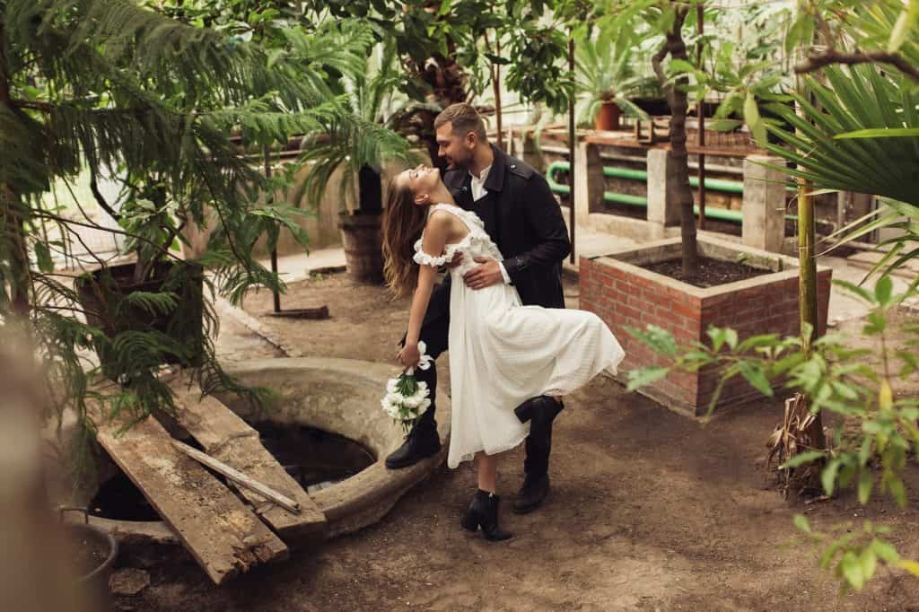Young gorgeous bride in white dress with little bouquet of flowe